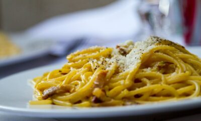 Close-up of spaghetti carbonara topped with grated Parmesan cheese on a plate, perfect for Italian cuisine lovers.