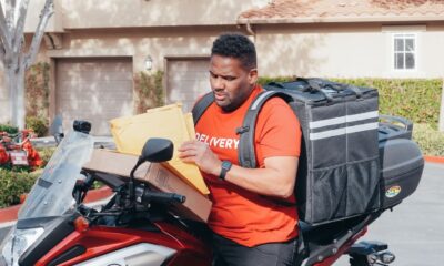 Man delivering parcels on a motorbike, illustrating the efficiency of package delivery services.