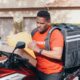 Man delivering parcels on a motorbike, illustrating the efficiency of package delivery services.